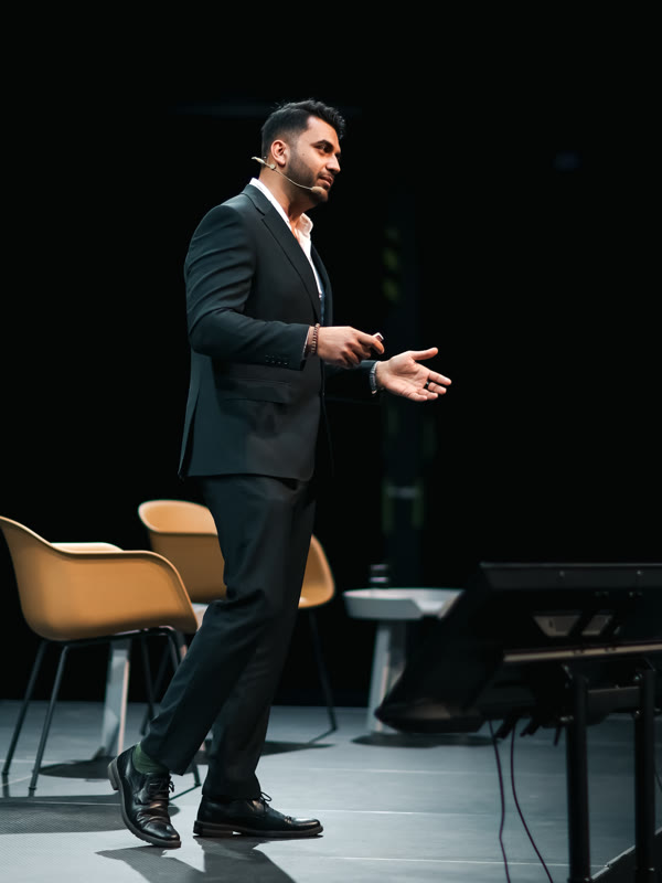 Bhanu Chawla delivering a keynote on stage, wide angle